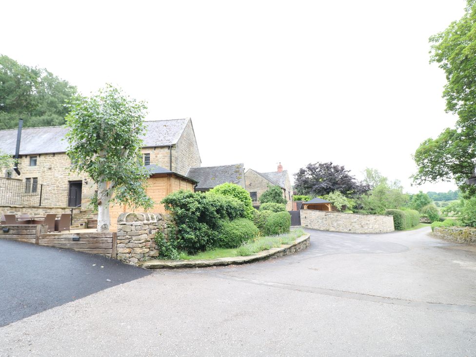 An outdoor view of a stone building and greenery at Orchard View in Oakerthorpe