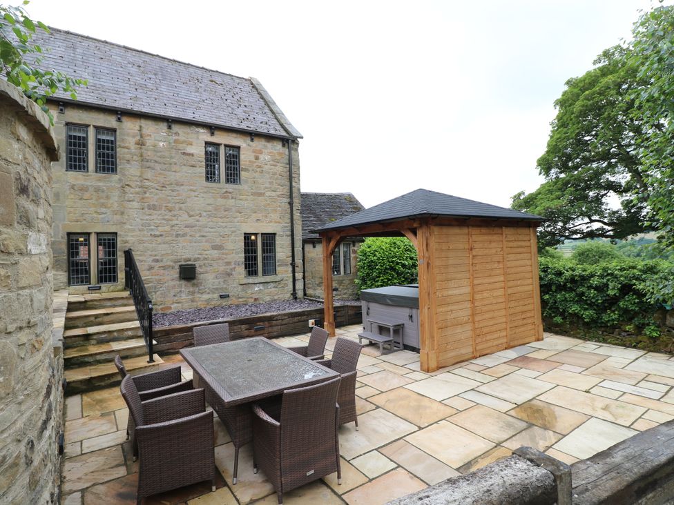An outdoor area with a table and chairs next to a hot tub at Orchard View in Oakerthorpe