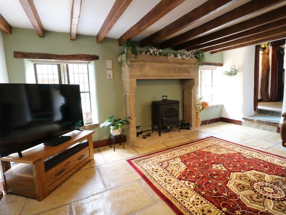 A living room with a television and a fireplace at Orchard View in Oakerthorpe