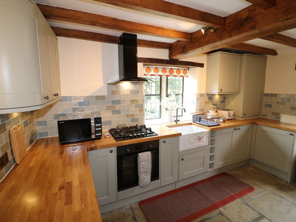 A kitchen with cabinets and appliances at Orchard View in Oakerthorpe