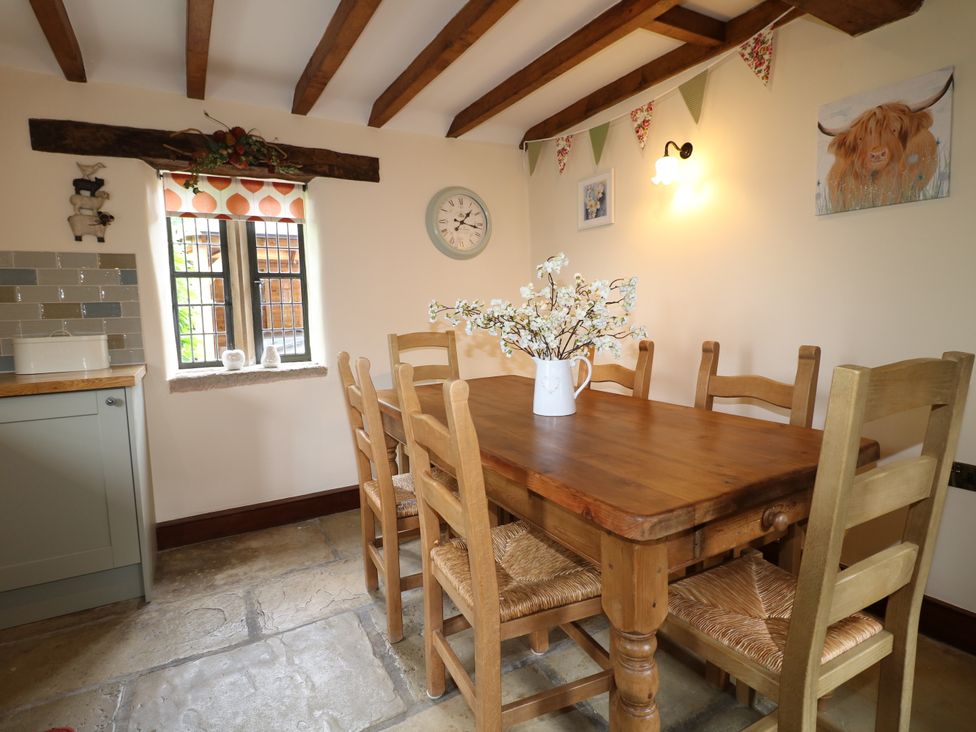 A dining room with a wooden table and chairs at Orchard View in Oakerthorpe