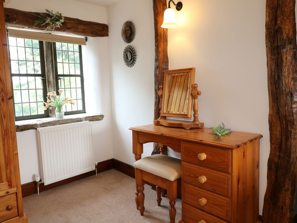 A bedroom with a wooden dresser and mirror at Orchard View Oakerthorpe