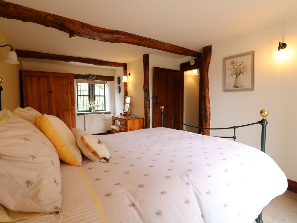 A bedroom with a bed and wooden furniture at Orchard View in Oakerthorpe