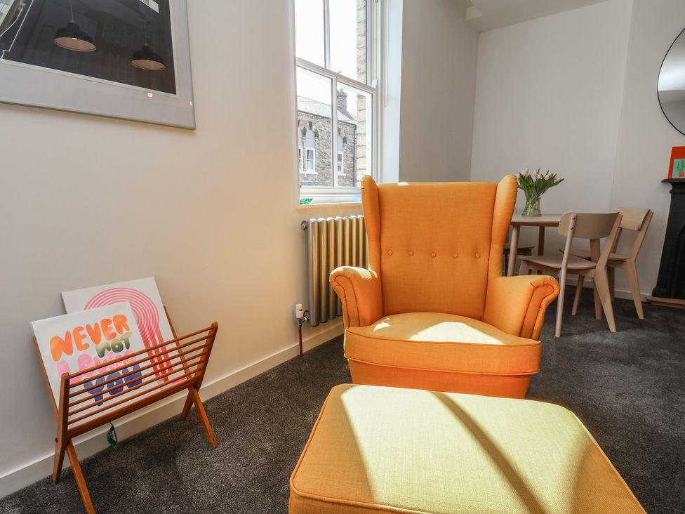 A living room with an armchair and a dining table at Nancy’s Blushes in Saltburn-by-the-Sea