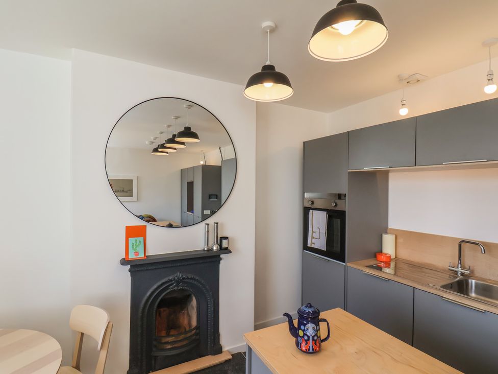 A kitchen with a mirror, table, and kitchen appliances at Nancy’s Blushes in Saltburn-by-the-Sea