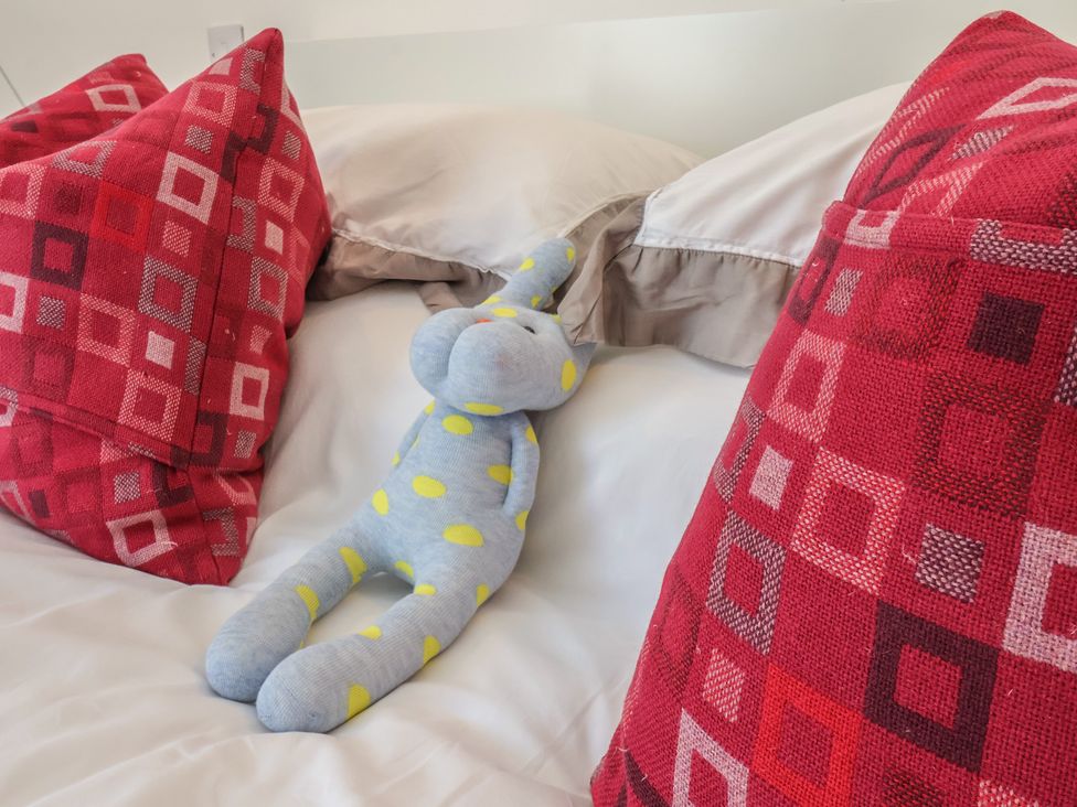 A bed with pillows and a textile toy at Nancy’s Blushes Saltburn-by-the-Sea