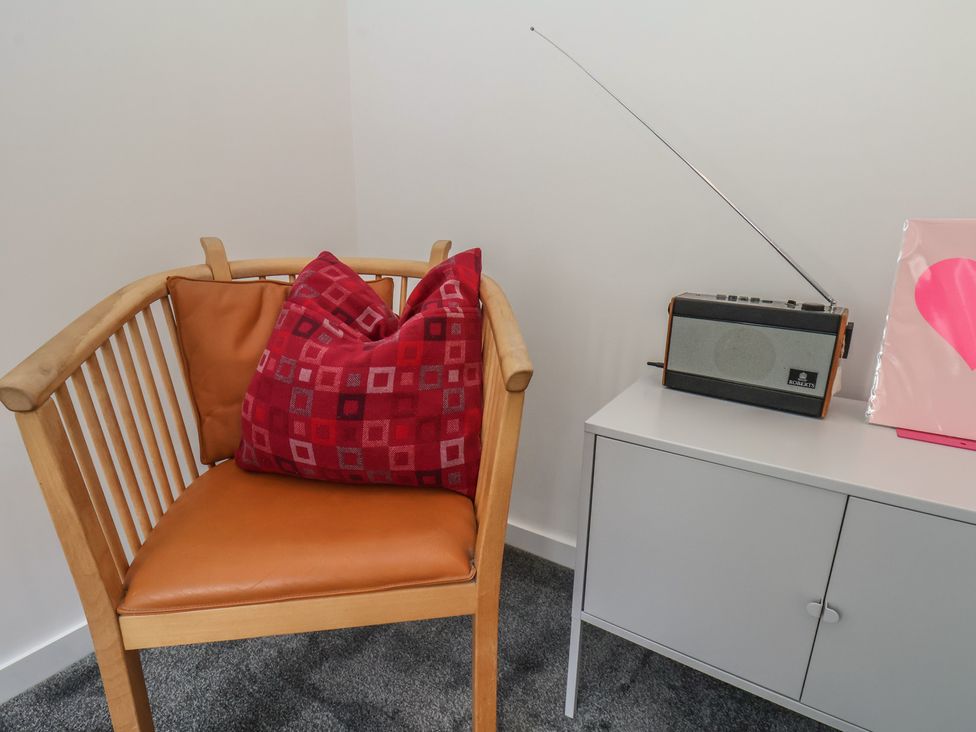 A living room with a chair and a radio at Nancy’s Blushes in Saltburn-by-the-Sea