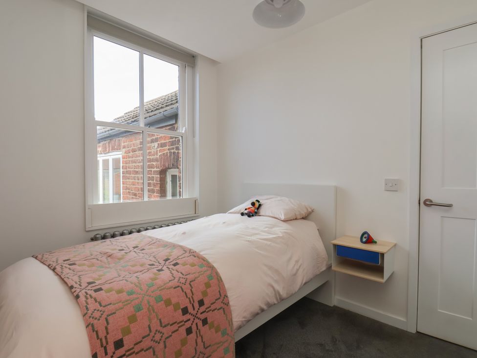 A bedroom with a bed and window at Nancy’s Blushes in Saltburn-by-the-Sea