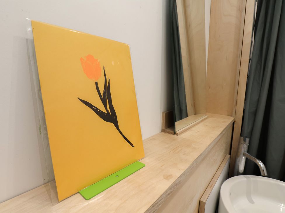 A bathroom with a flower print and mirror at Nancy’s Blushes in Saltburn-by-the-Sea