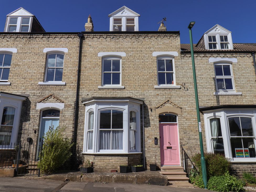 A row of houses with a pink door and windows at Nancy’s Blushes in Saltburn-by-the-Sea