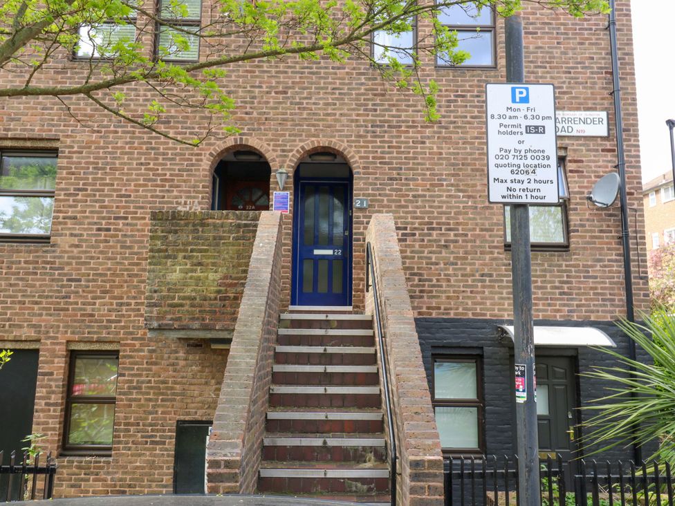 An outdoor view of a brick building entrance with stairs and parking sign at 22A Warrender Road Tufnell Park