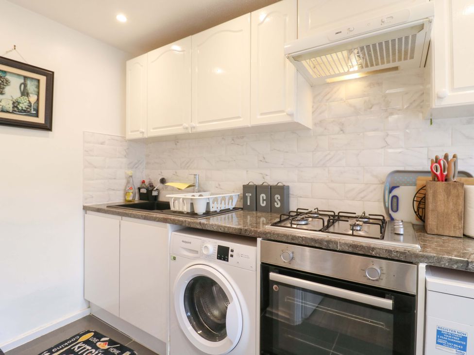 A kitchen with washing machine and gas stove at 22A Warrender Road Tufnell Park