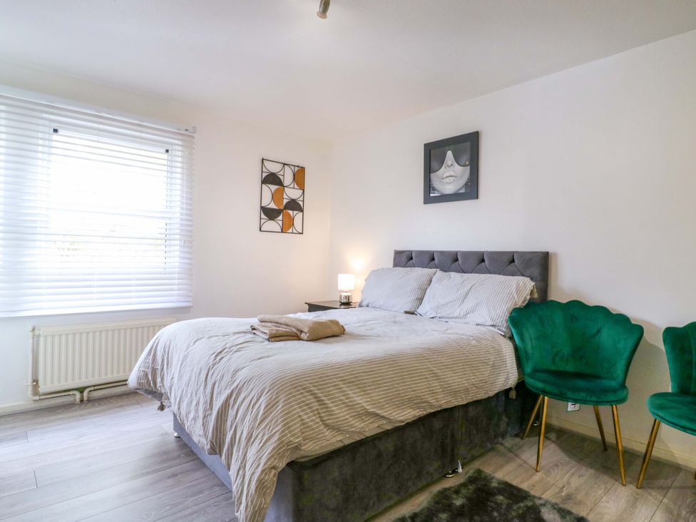 A bedroom with a bed and chairs at 22A Warrender Road Tufnell Park