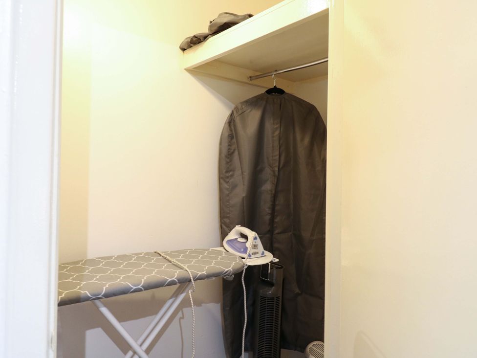 A laundry room with an ironing board and iron at 22A Warrender Road, Tufnell Park