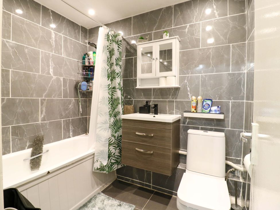 A bathroom with a bathtub and storage cabinet at 22A Warrender Road Tufnell Park