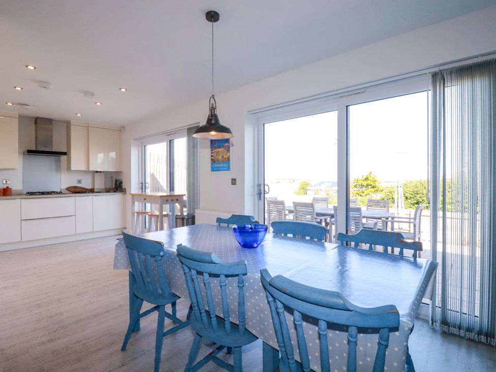 A kitchen with a dining table and chairs at Serfaus Perranporth