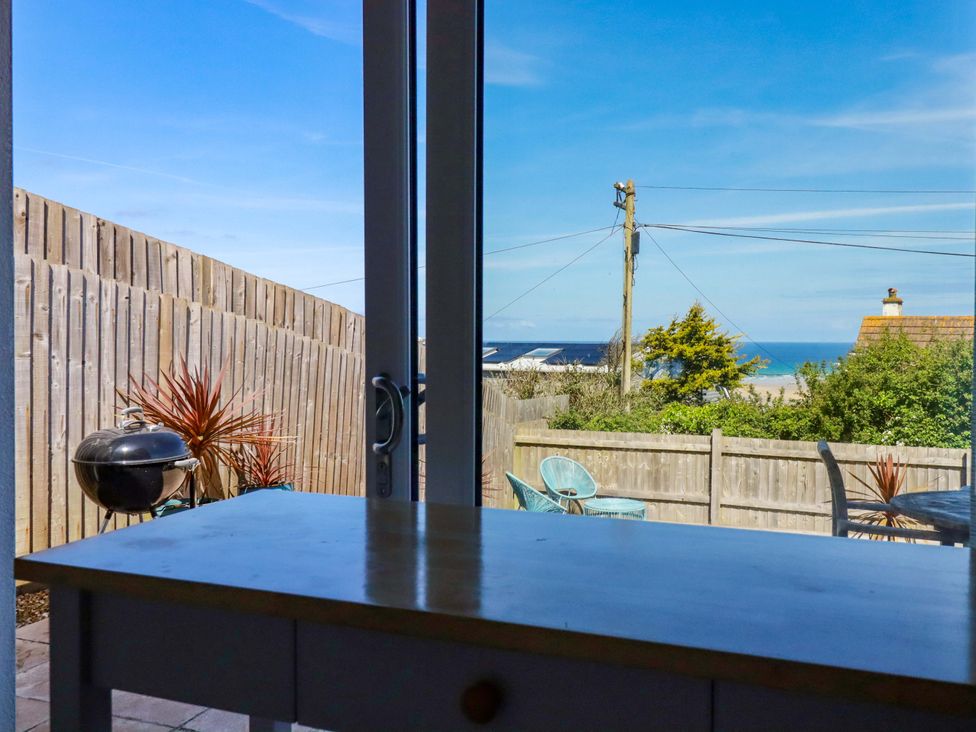 A view from a window showing a table and outdoor seating at Serfaus in Perranporth