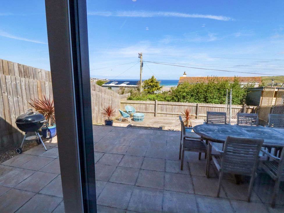 A garden with a table and chairs overlooking the sea at Serfaus in Perranporth