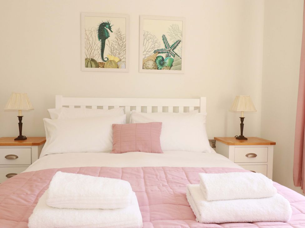 A bedroom with a bed and wall art at Serfaus in Perranporth