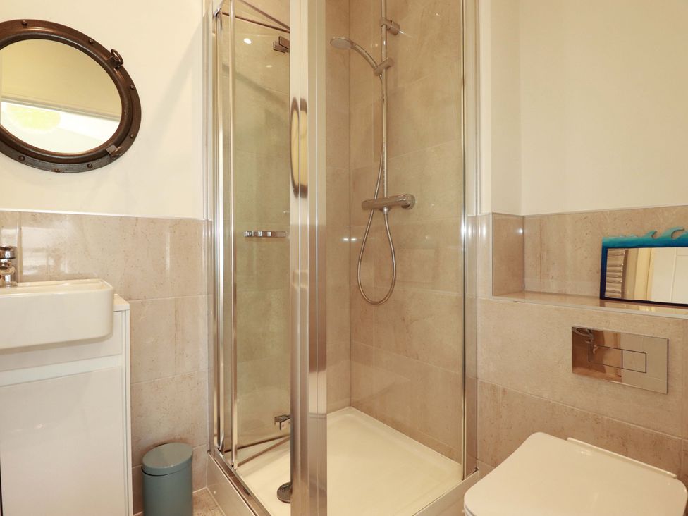 A bathroom with a shower, toilet and sink at Serfaus in Perranporth