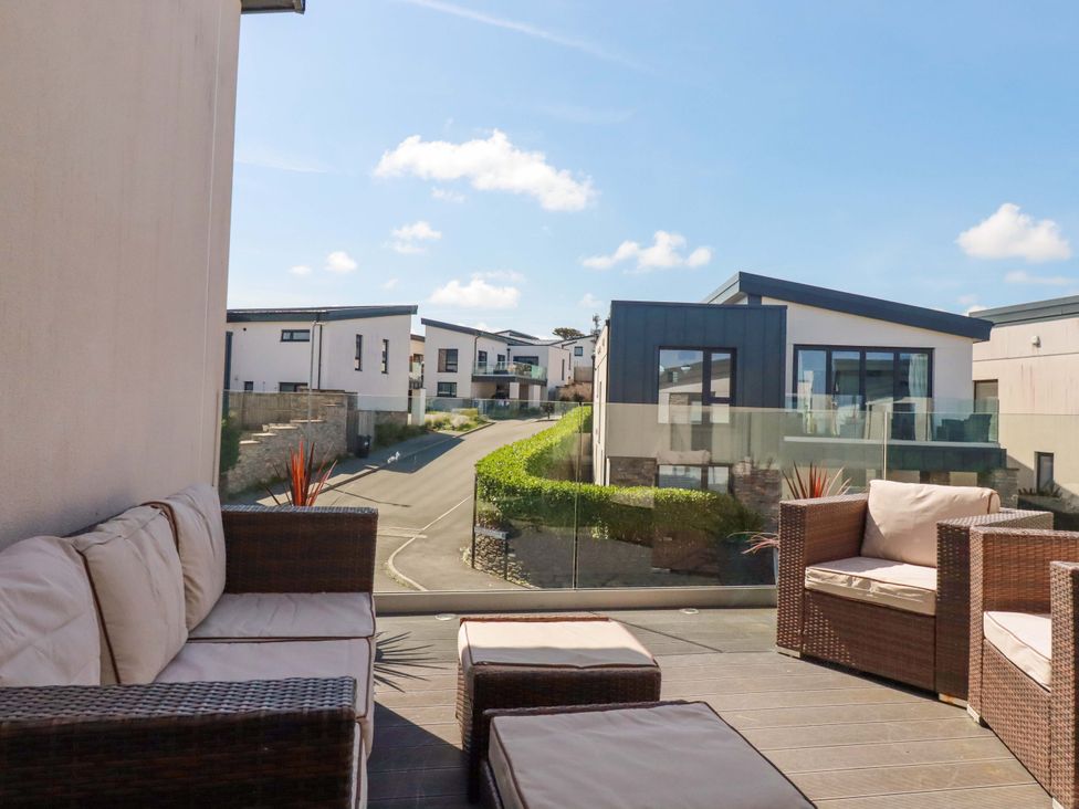 An outdoor seating area with a view of buildings at Serfaus in Perranporth