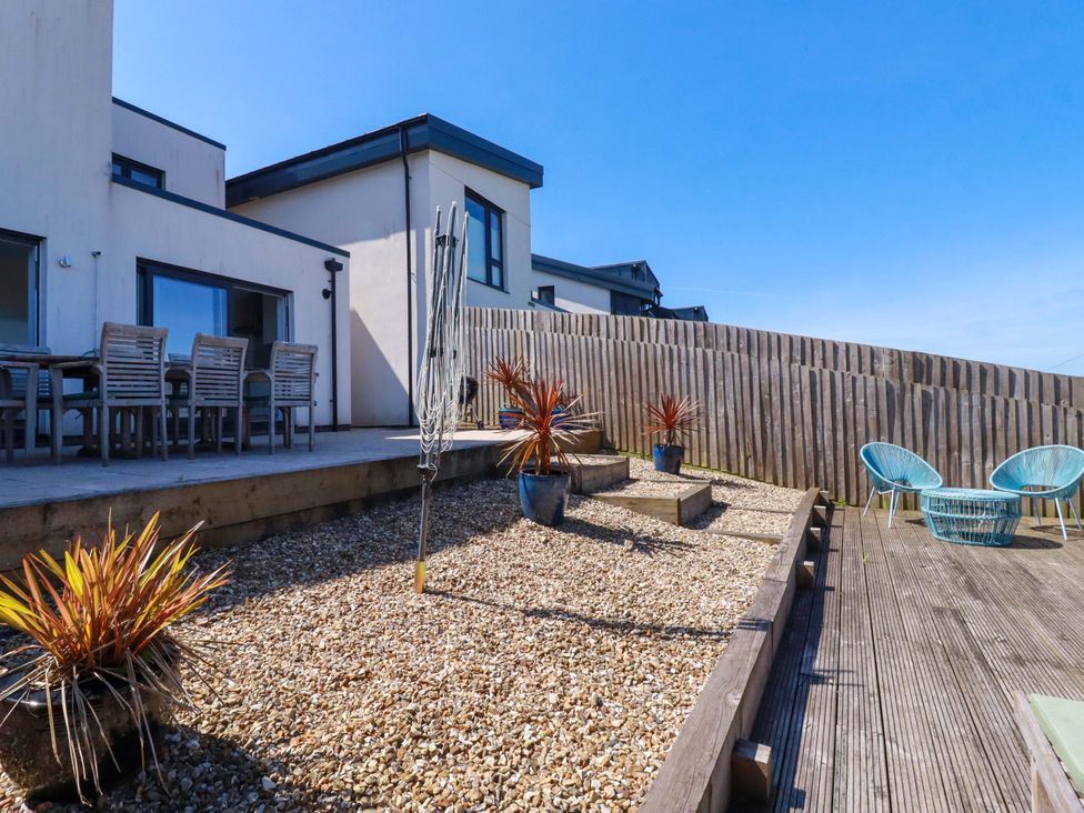 A garden with decking and potted plants at Serfaus in Perranporth