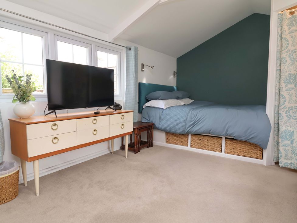 A bedroom with a bed and television at The Apple Loft in Exeter
