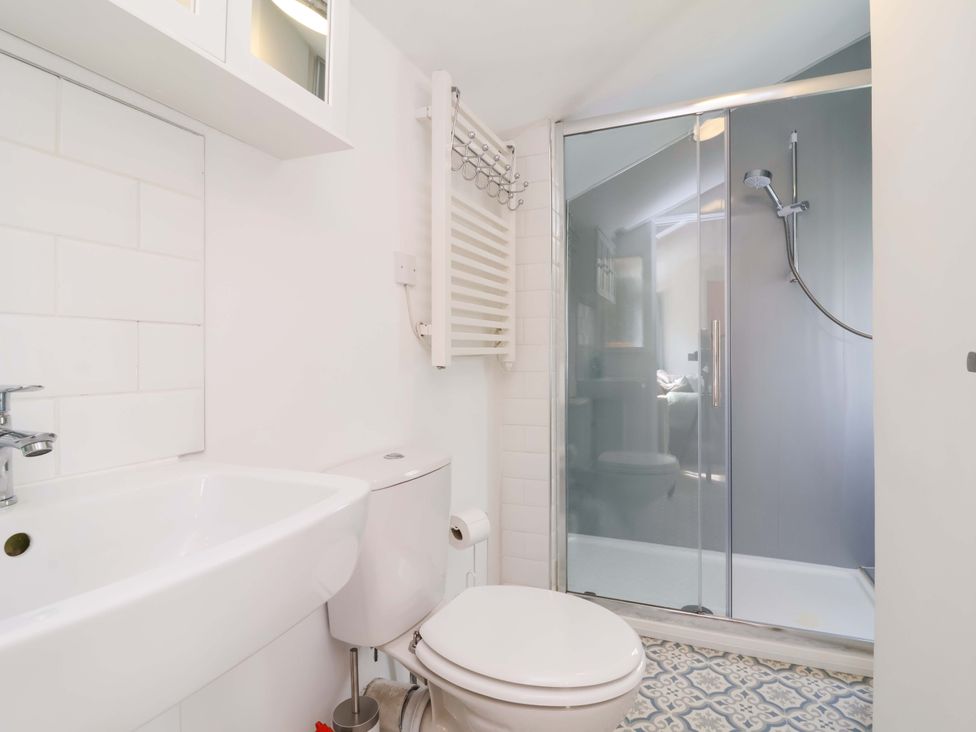 A bathroom with a sink and toilet beside a shower at The Apple Loft in Exeter