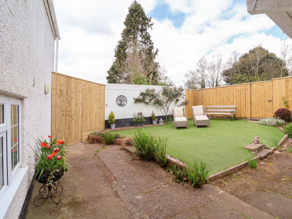 A garden with loungers and a bench at The Apple Loft in Exeter