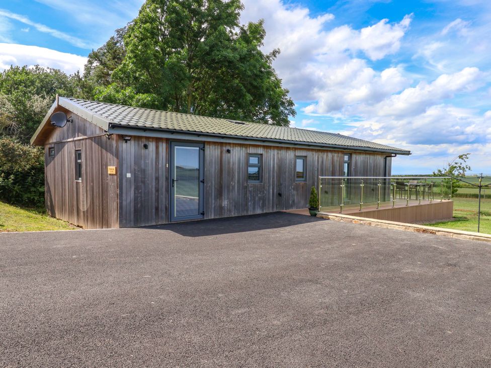 A wooden building with a deck at Freedom Lodge @ Summerfield Farm Whitby