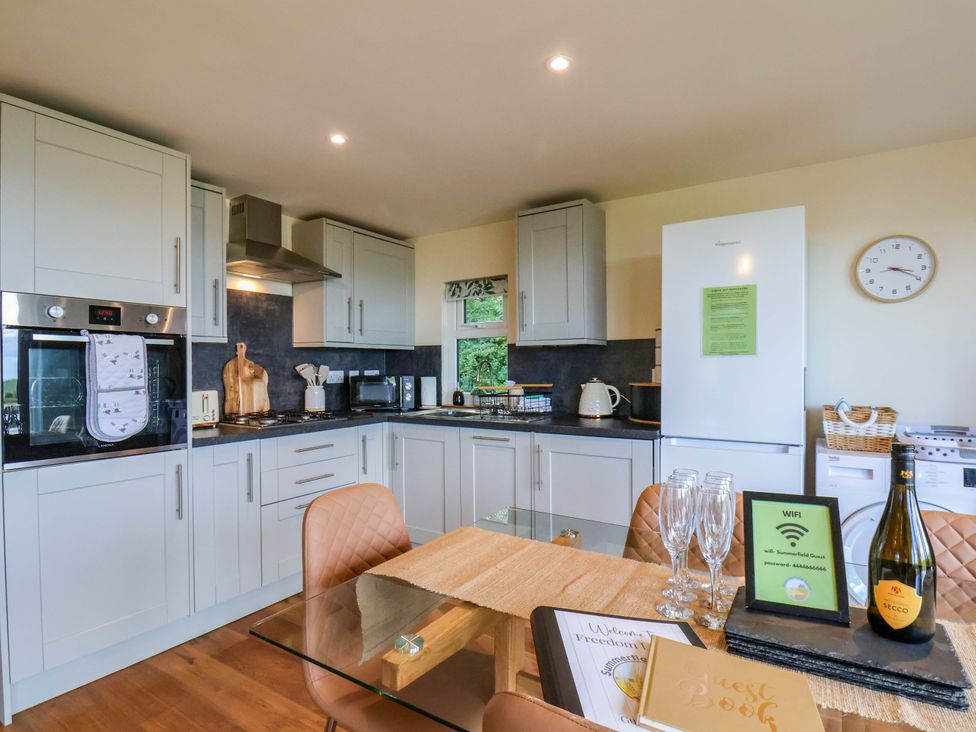 A kitchen with appliances and dining area at Freedom Lodge @ Summerfield Farm Whitby