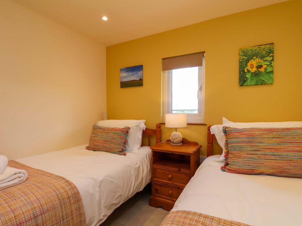 A bedroom with two beds and a nightstand at Freedom Lodge @ Summerfield Farm in Whitby