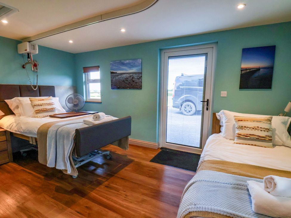 A bedroom with two beds and a door at Freedom Lodge @ Summerfield Farm in Whitby