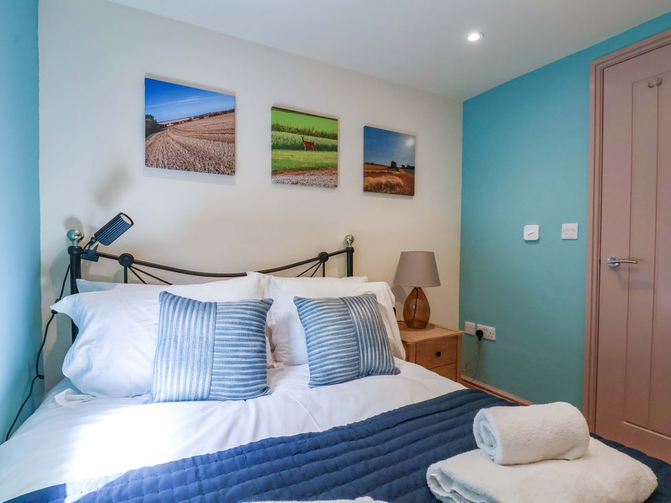 A bedroom with a bed and wall art at Freedom Lodge @ Summerfield Farm, Whitby