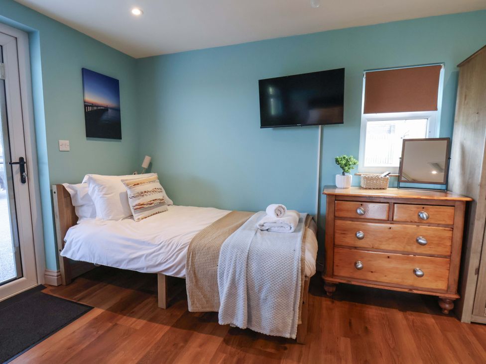 A bedroom with a bed and a television at Freedom Lodge @ Summerfield Farm Whitby