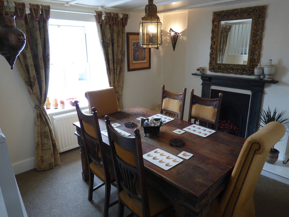 A dining room with a table and chairs at Trelake Cottage