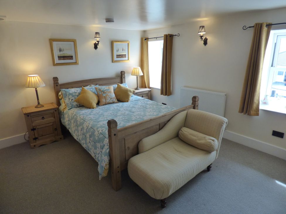 A bedroom with a bed and nightstand at Trelake Cottage in 