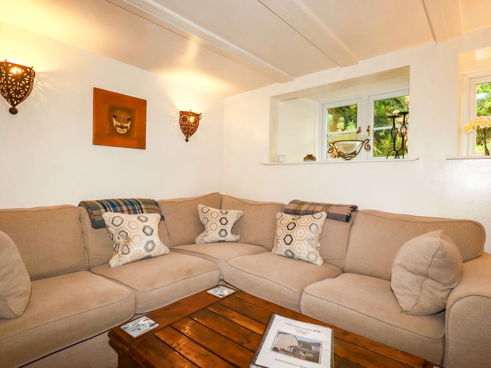 A living room with a sofa and coffee table at Trelake Cottage in Tintagel