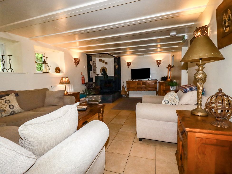 A living room with a sofa and television at Trelake Cottage Tintagel