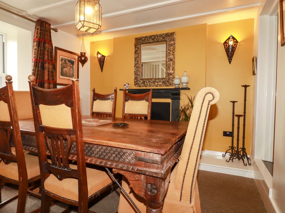 A dining room with a wooden table and chairs at Trelake Cottage in Tintagel