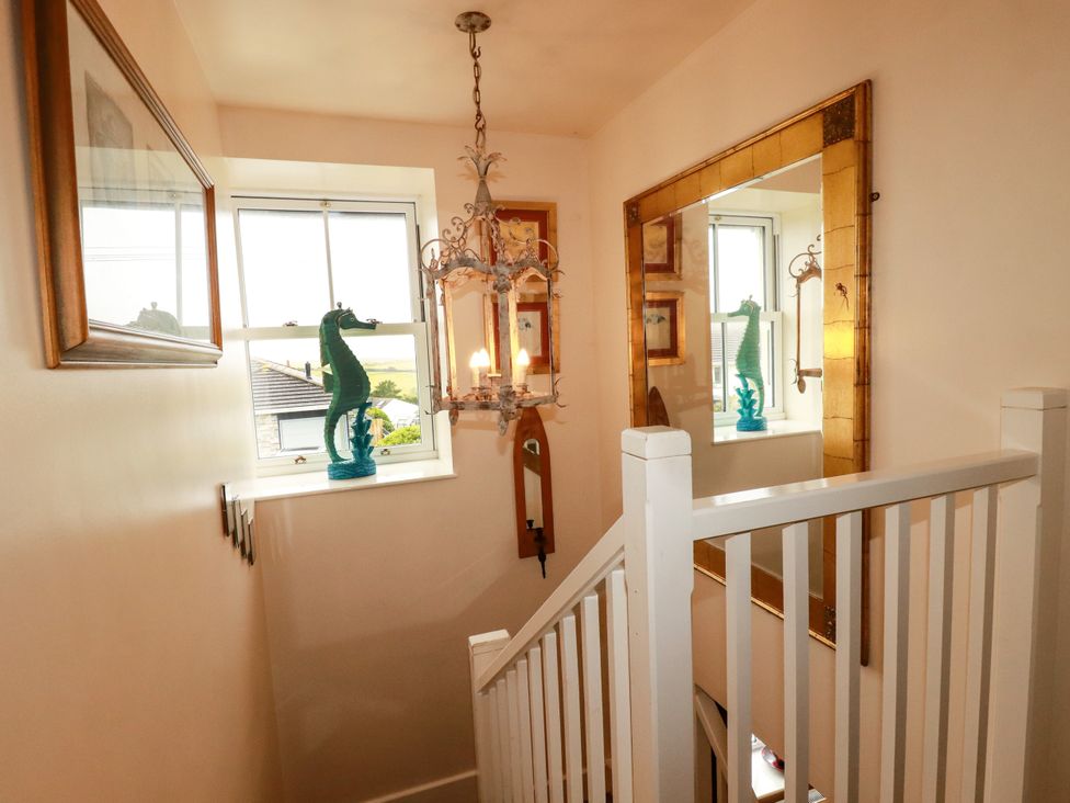 A hallway featuring a chandelier and a mirror at Trelake Cottage in Tintagel