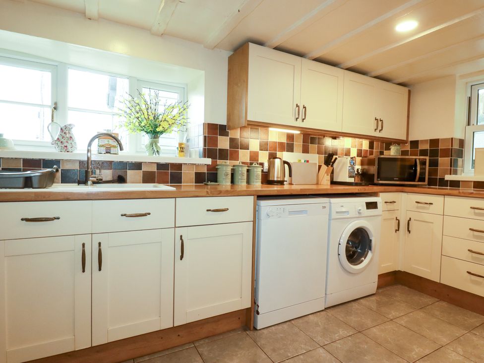 A kitchen with a sink and appliances at Trelake Cottage in Tintagel