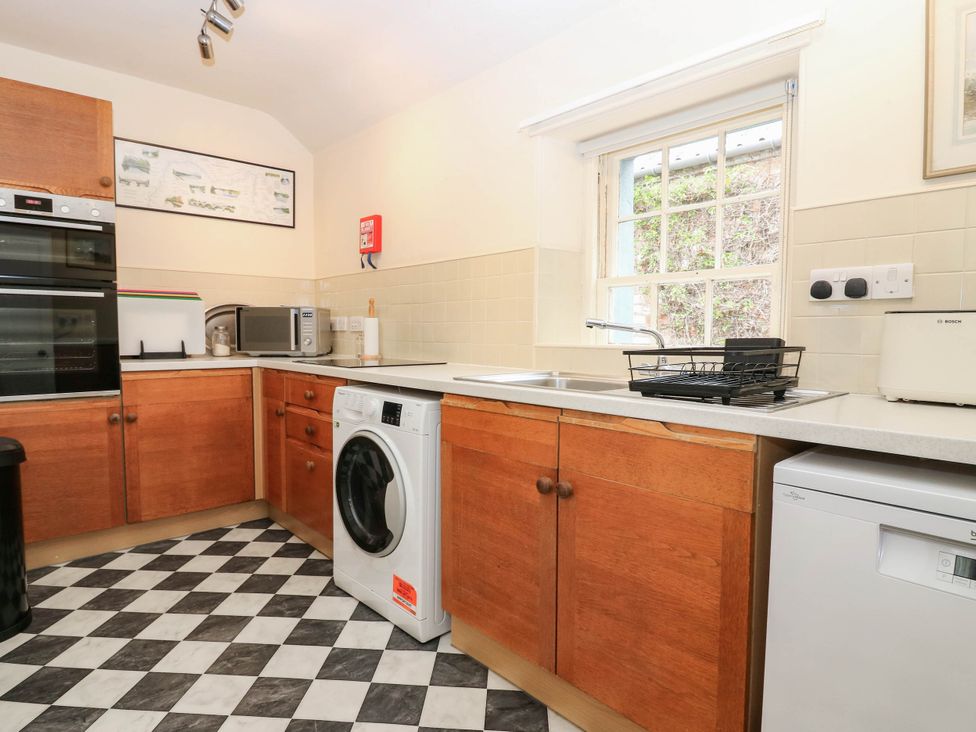 A kitchen with appliances and cabinets at Gardener’s cottage in Stanley
