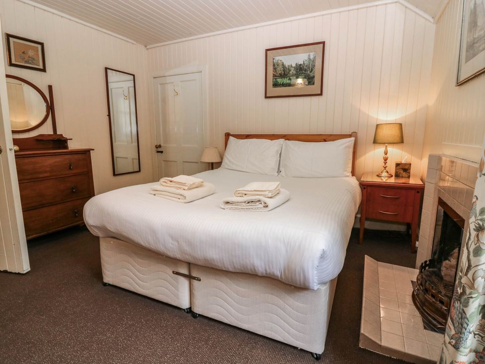 A bedroom with a bed and furniture at Gardener’s cottage in Stanley