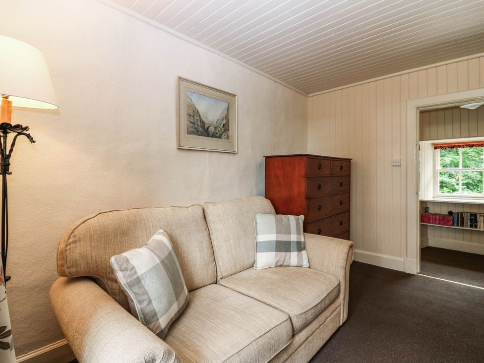 A snug room with a sofa and a window at Gardener’s cottage in Stanley