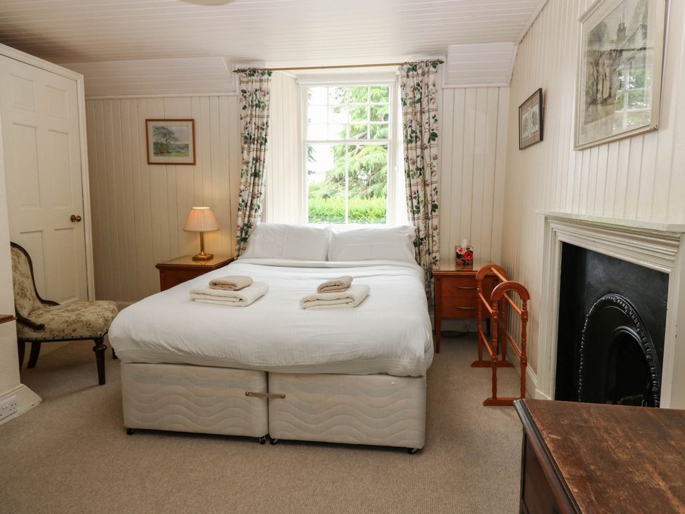 A bedroom with a bed and bedside table at Gardener’s cottage in Stanley