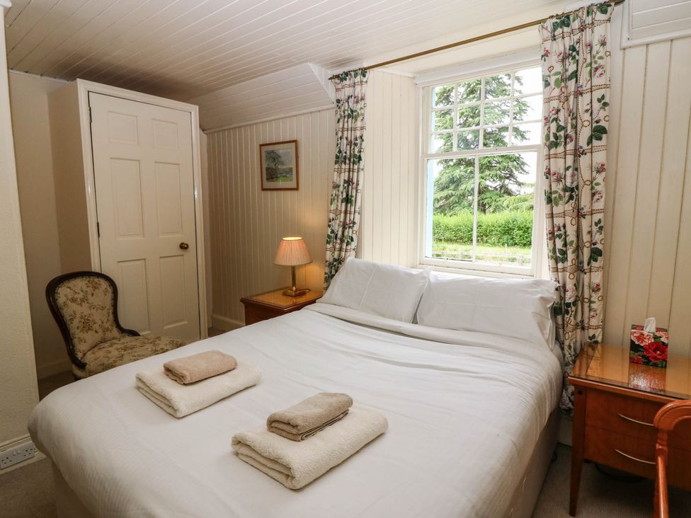 A bedroom with a bed and a window at Gardener’s cottage in Stanley