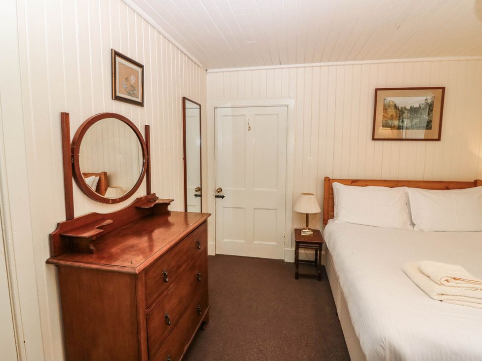 A bedroom with a bed and dresser at Gardener’s cottage in Stanley