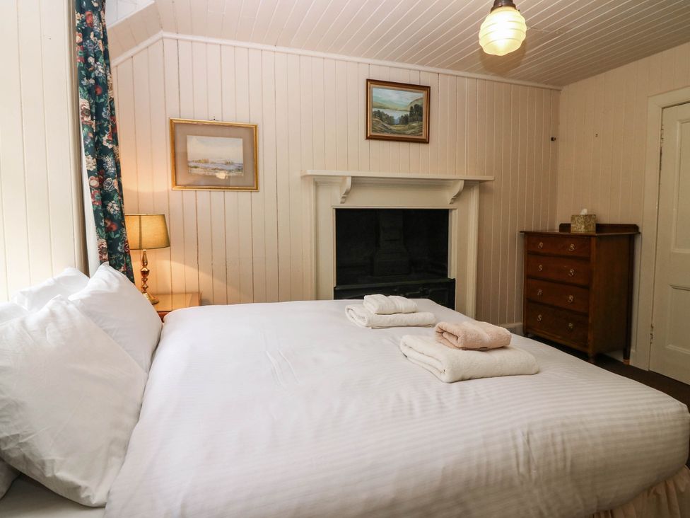 A bedroom with a bed and lamp at Gardener’s cottage in Stanley