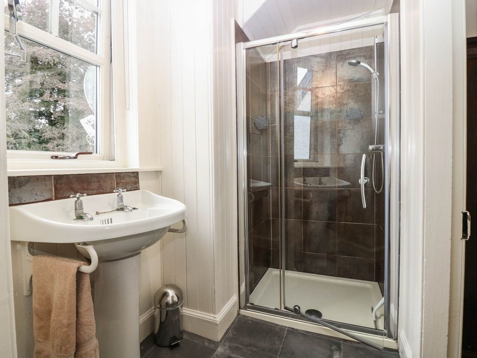 A bathroom with a shower and sink at Gardener’s cottage in Stanley